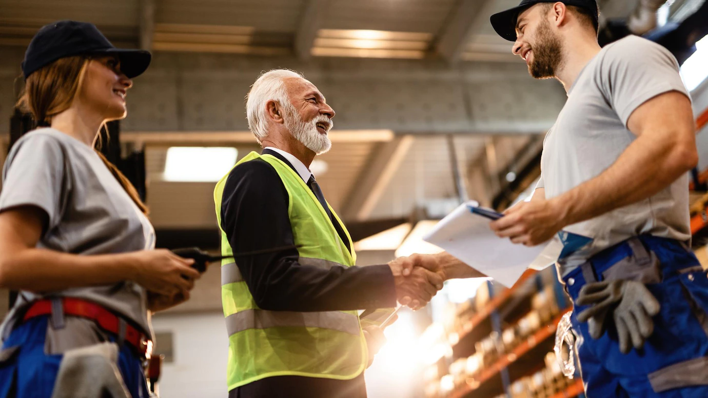 low-angle-view-happy-senior-manager-greeting-his-employees-factory-warehouse-me-are-shaking-hands_637285-4192